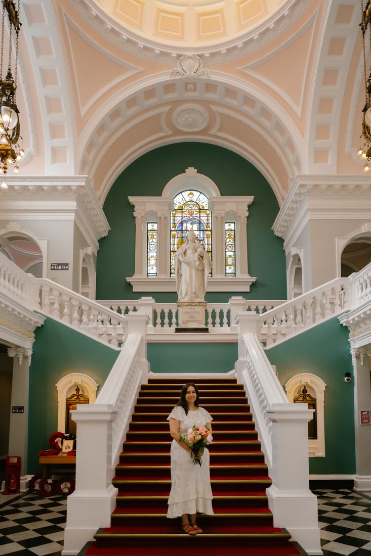 Bride on a grand red-carpeted staircase