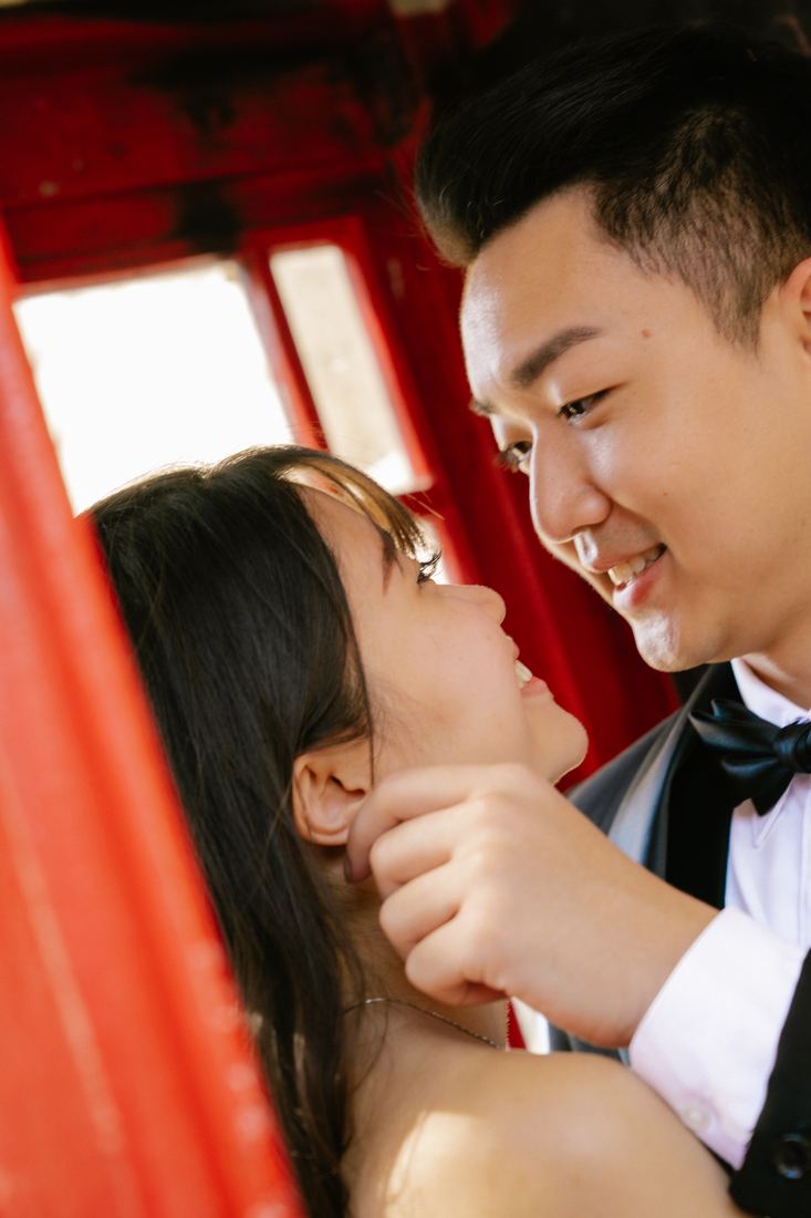 Couple nose to nose inside a red phone box