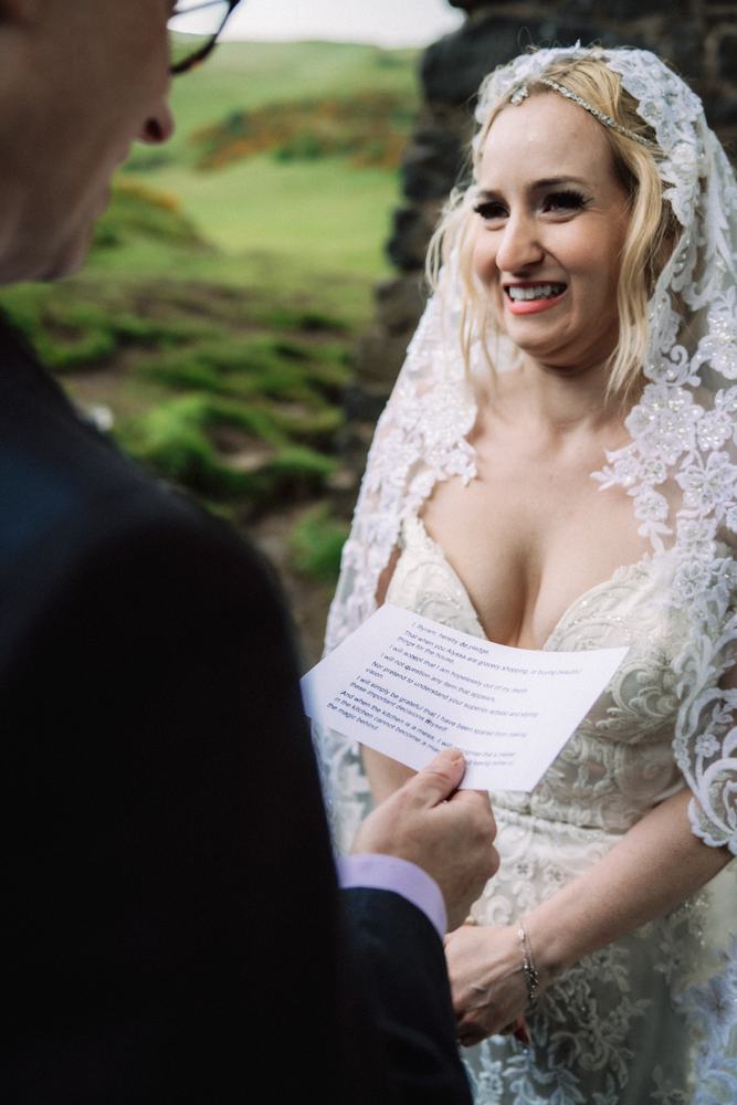 Bride smiling while her partner reads his vows