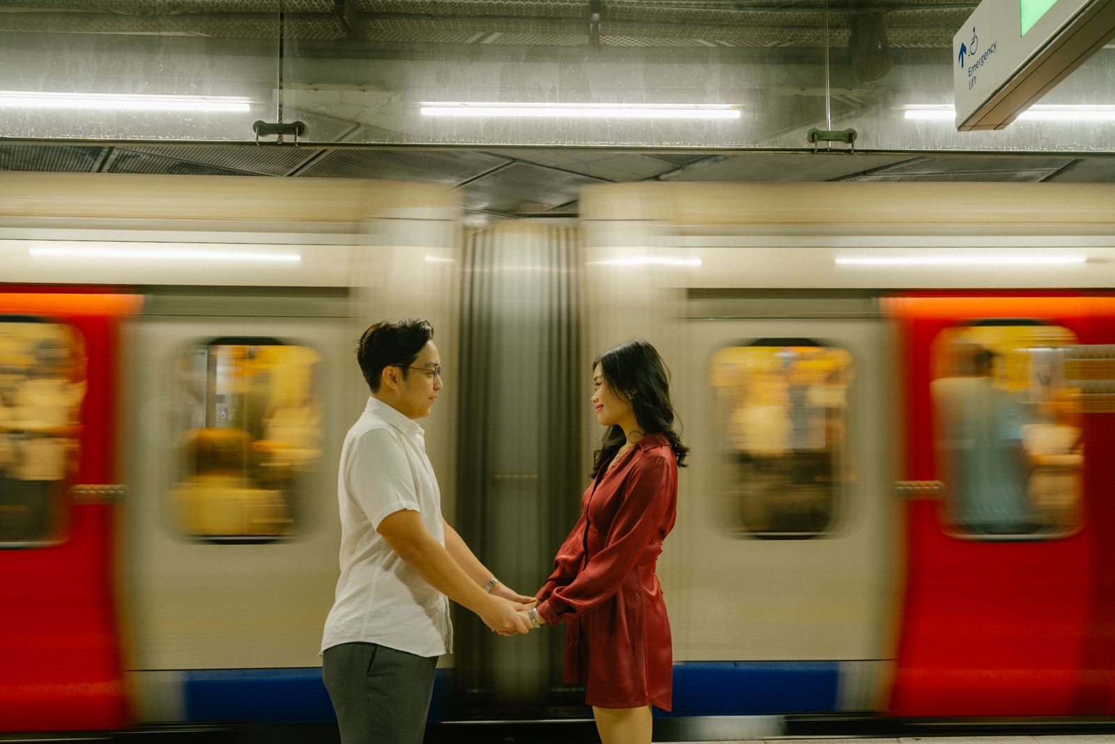 Couple holding hands as a Tube train rushes past