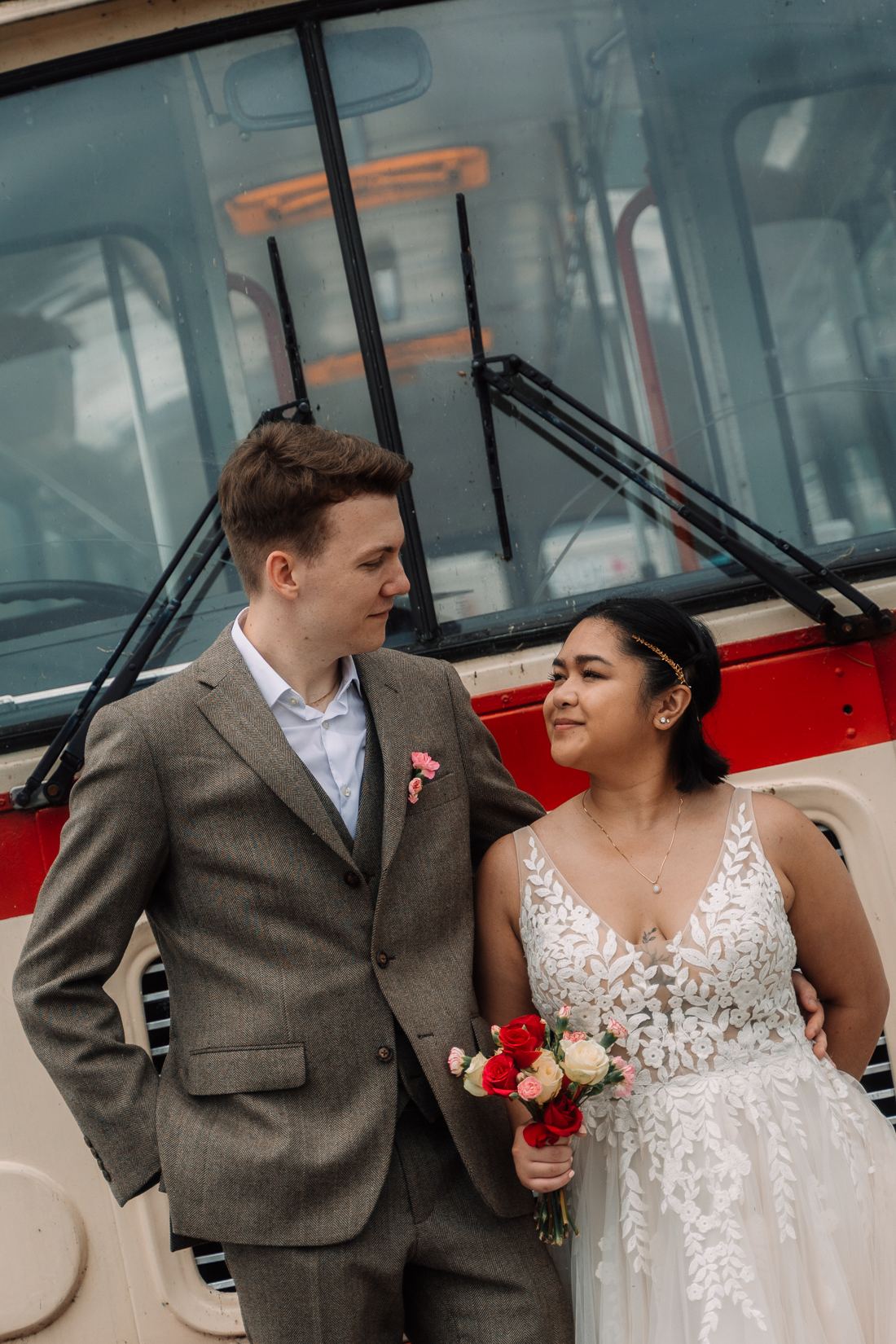 Bride and groom in front of a vintage bus