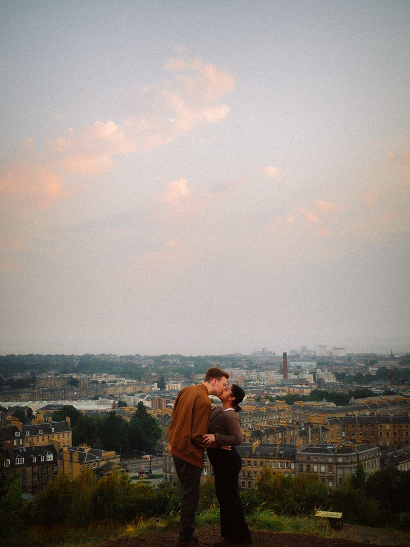 Couple embracing above the Edinburgh skyline at dusk