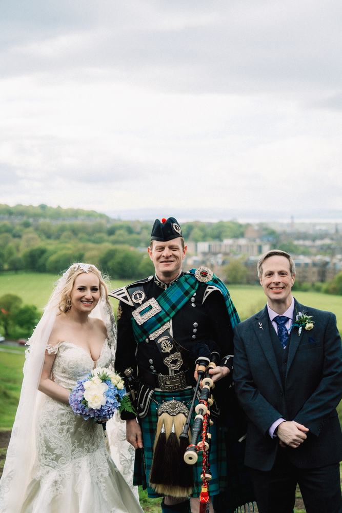 Couple with a bagpiper on Arthur's Seat