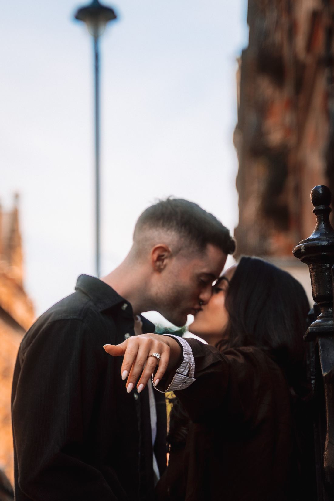 Couple kissing as she shows off her ring