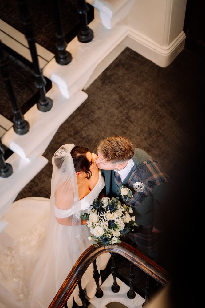 Newlyweds kissing on a staircase, seen from above